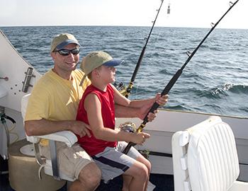 Dad and son fishing on a charter together