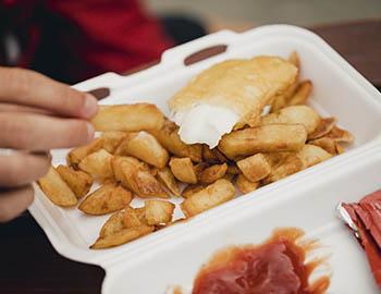 Fried fish and fries in a to-go container