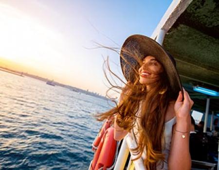 Girl holding onto her big sunhat on the ferry