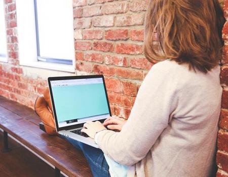 Woman sitting on a bench on her computer