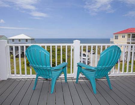 Two beach chairs on a balcony of a vacation rental