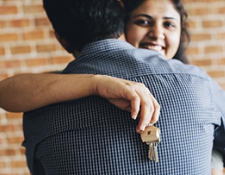 Happy wife hugging her husband after buying a new home