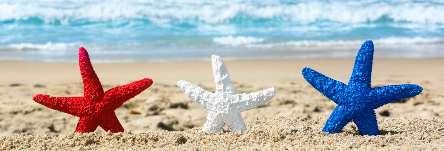 Red, white and blue starfish lined up on the beach