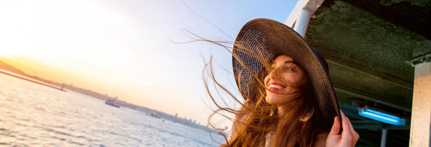 Girl with a big sunhat on a ferry boat