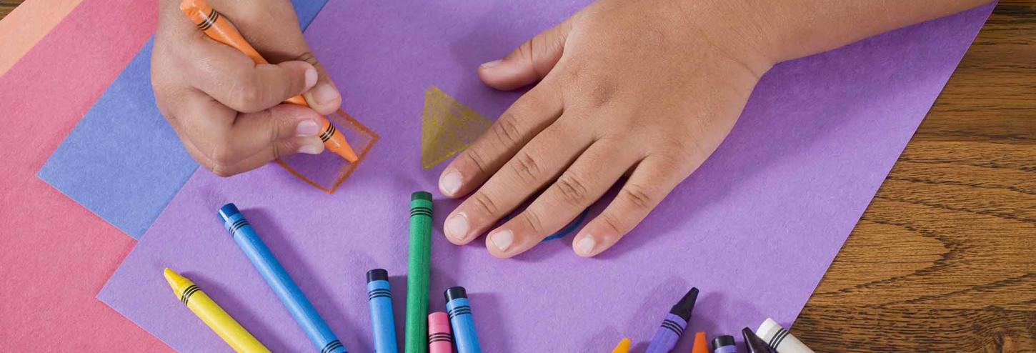 Young child coloring with crayons