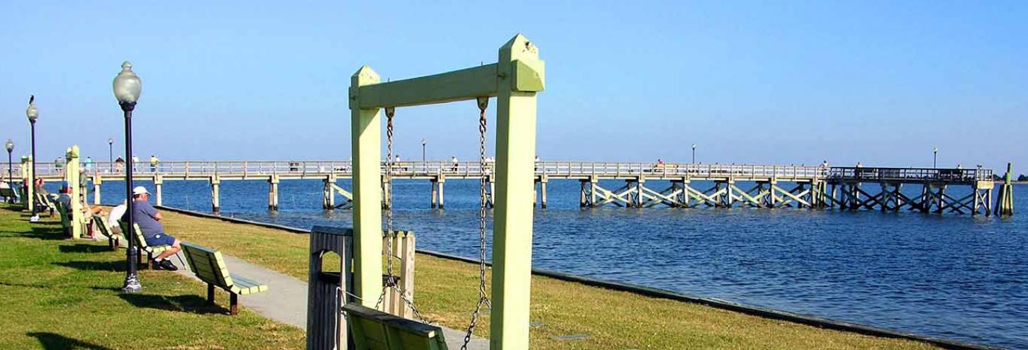 The pier and people sitting on benches at Southport in North Carolina