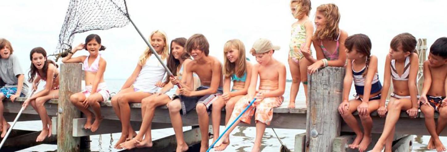 Kids sitting on a dock at a vacation rental home