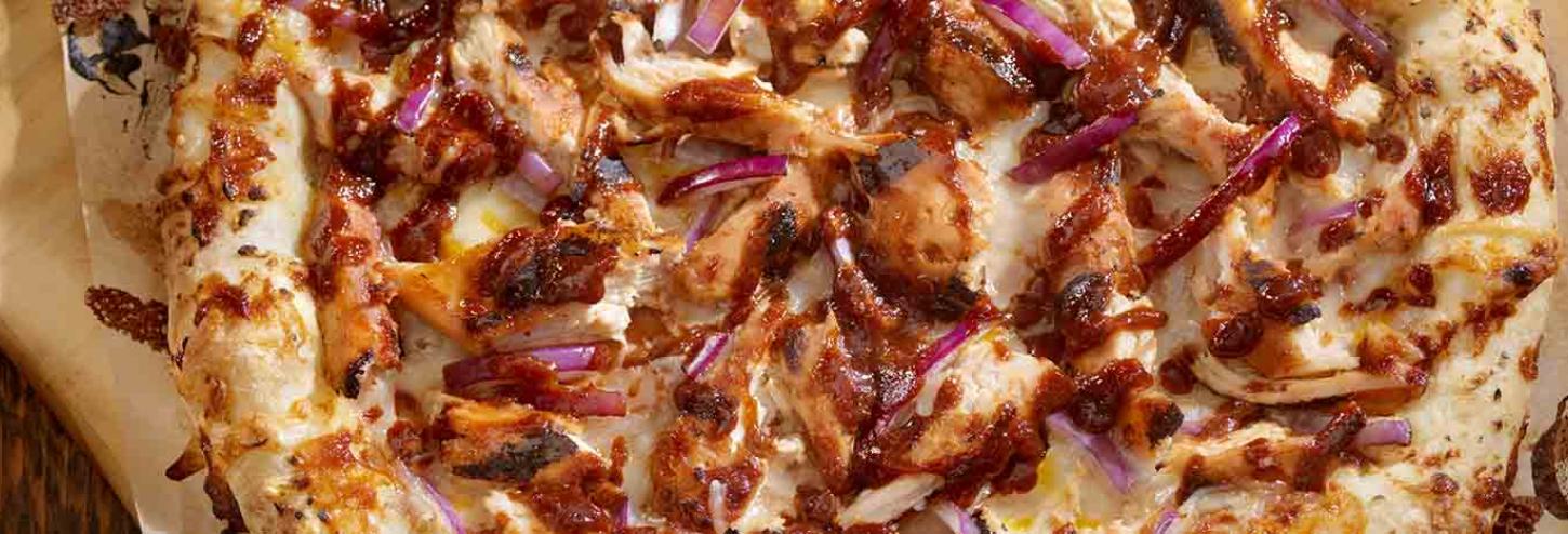 A pizza topped with BBQ