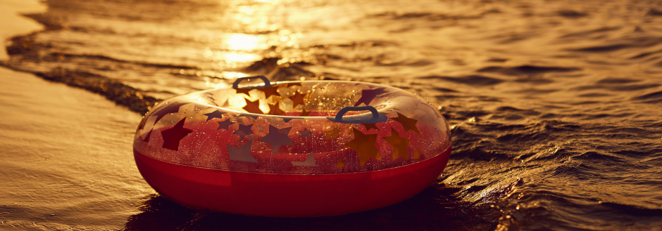 end of summer, inner tube floats in the setting sun in the waves