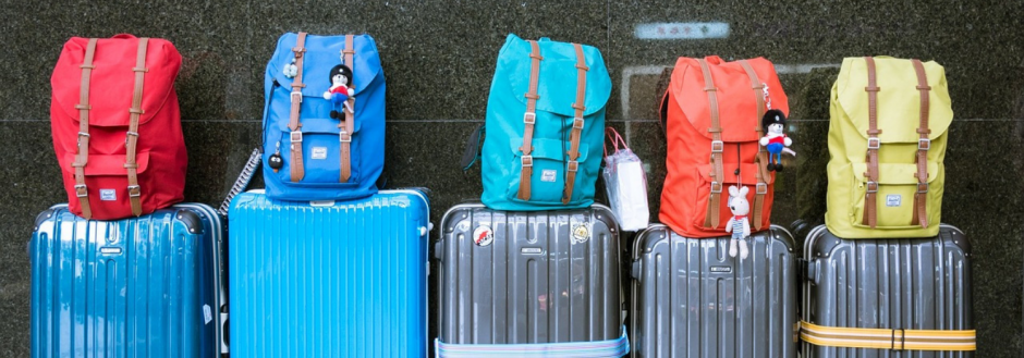 Suitcases and backpacks lined up and ready for a vacation