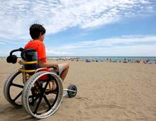 Boy on the beach in a beach wheelchair