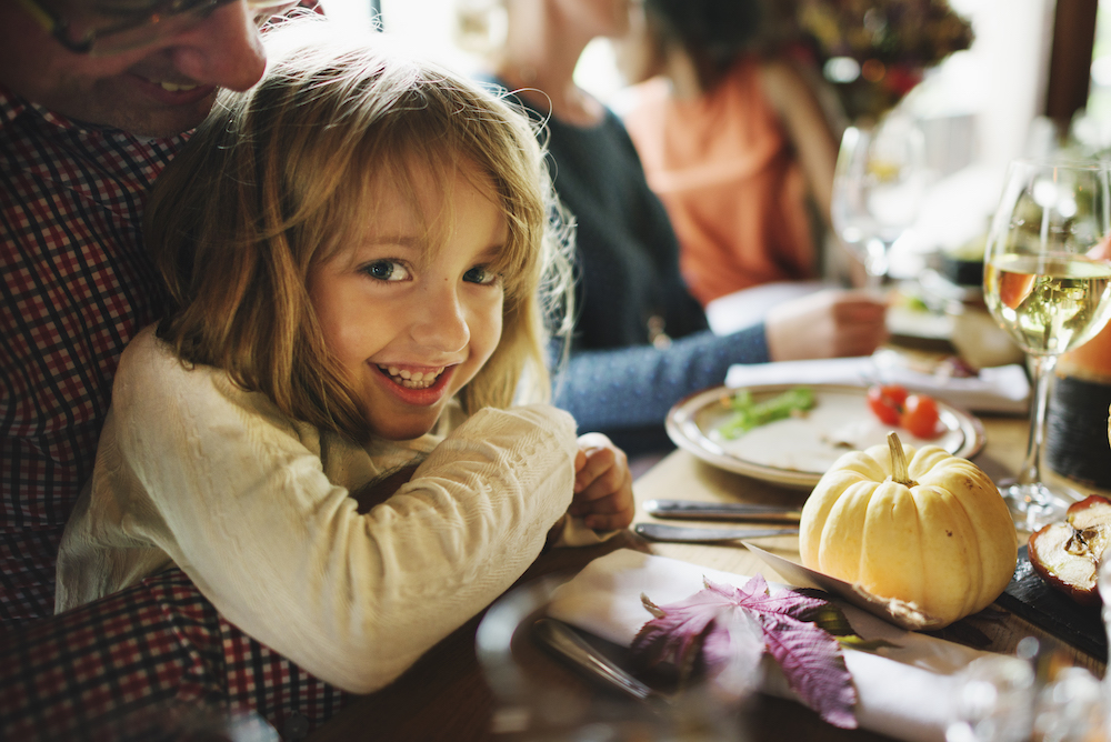 kid in lap of parent at dinner table 
