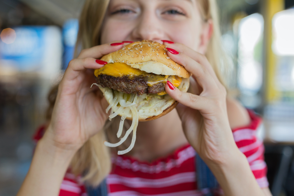 Blonde Woman Eating Cheeseburger