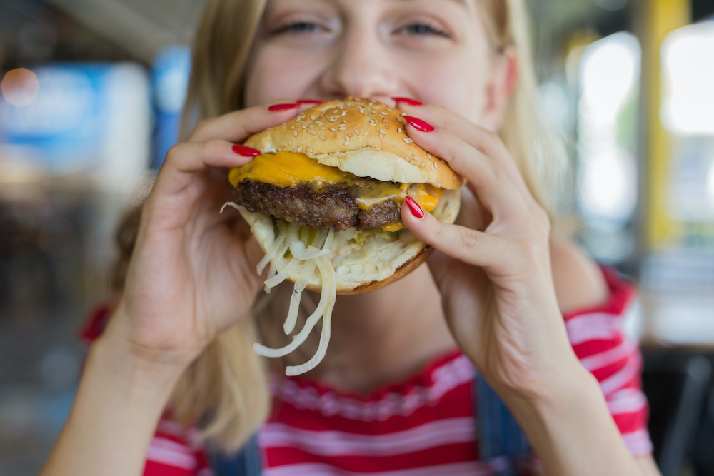 Little Bit's Grill Burgers & Lemonade Blonde Woman Eating Cheeseburger