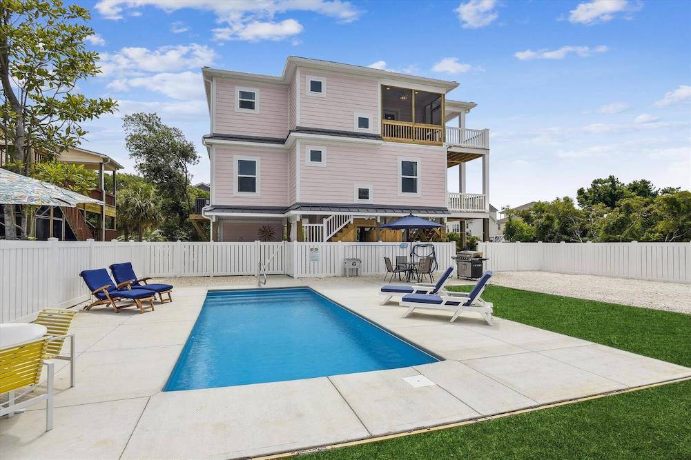 Cute pink beach house with lovely in-ground pool, fenced in yard and well manicured lawn