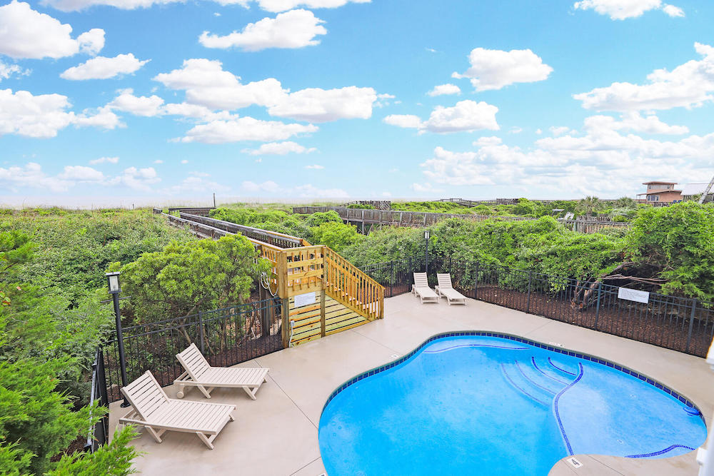 Sea Winds vacation rental on oak island with view of in-ground pool facing the beach