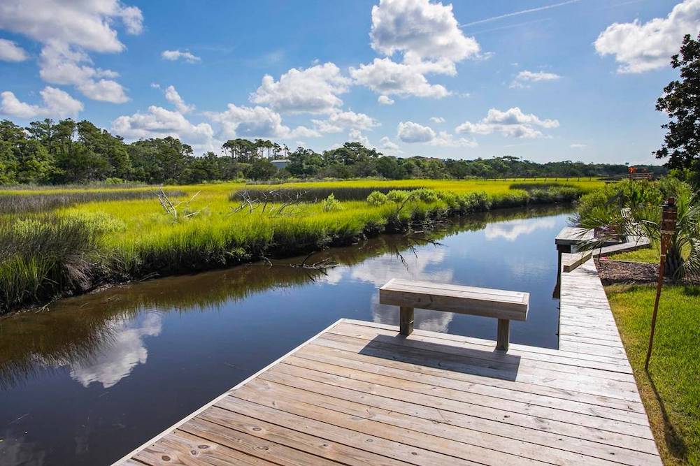 dock on marshland with a small bench to sit on