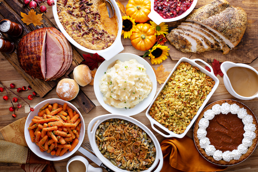 aerial of thanksgiving table with ham and turkey and all the sides